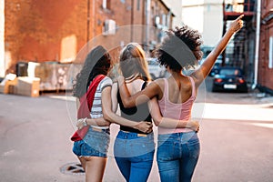 Multi ethnic female friends walking on street