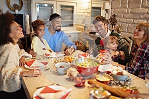 Multi ethnic friends have fun at a family Christmas dinner