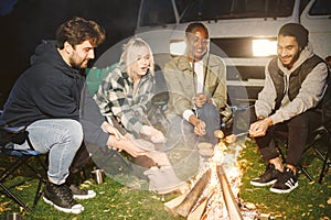 Multi ethnic friends having picnic by fireplace