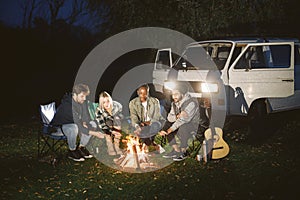 Multi ethnic friends having picnic by fireplace