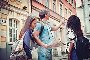 Multi ethnic friends tourists with map in old city photo