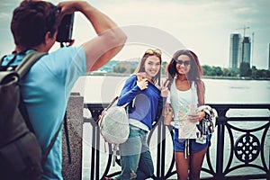Multi-ethnic friends tourists taking photo near river in a city photo