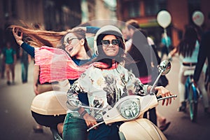 Multi ethnic girls on a scooter in european city