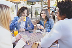 Multi-ethnic group of friends having a drink together in an outdoor bar.