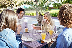 Multi-ethnic group of friends having a drink together in an outdoor bar.