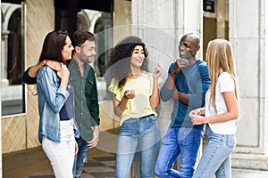 Multi-ethnic group of friends having fun together in urban background photo