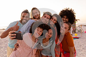 Multi-ethnic group of male and female taking a selfie on the beach