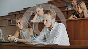 Multi Ethnic Group of Students Using Smartphones During the Lecture. Young People Using Social Media while Studying in