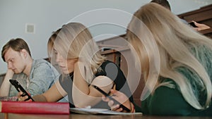 Multi Ethnic Group of Students Using Smartphones During the Lecture. Young People Using Social Media while Studying in