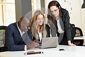 Multi-ethnic group of three businesspeople meeting in a modern o