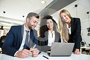 Multi-ethnic group of three businesspeople meeting in a modern o