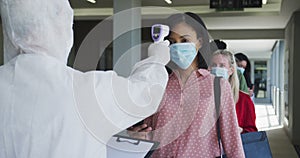 Multi-ethnic group working in casual office, in face mask protecting from Covid 19 standing in line