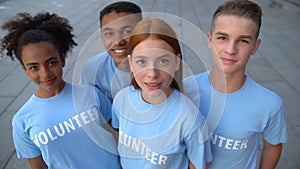 Multi-ethnic group of young volunteers looking camera, altruistic activity, help