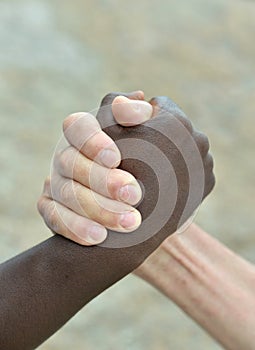 Multi-Ethnic hands in handshake close-up on abstract background