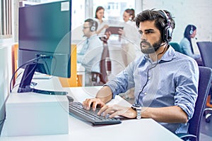 Multi ethnic handsome man in formal shirt tying on keyboard confidential user's credentials at support center.