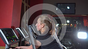 Multi ethnic people keeping fit exercising on modern gym equipment. Sports beautiful women in the gym. The trainer play