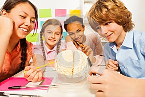 Multi ethnic students studying anatomy at class