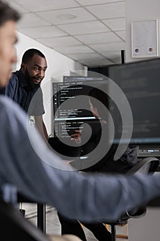 Multi ethnic team of software developers talking about html code