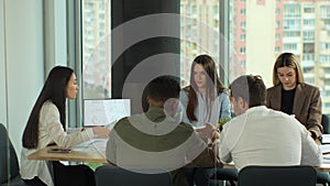 Multi-ethnic team of start-up entrepreneurs, software engineers, have meeting in the modern office conference room