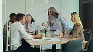 Multi-ethnic team of start-up entrepreneurs, software engineers, have meeting in the modern office conference room