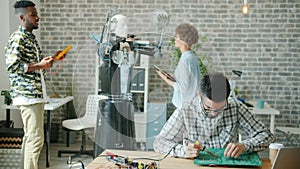 Multi-ethnic team working in office testing droid soldering circuit board