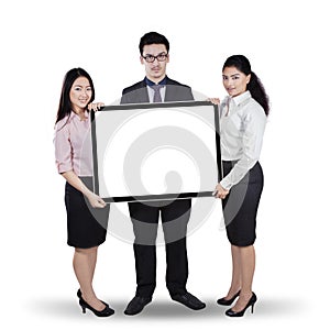 Multi ethnic teamwork holding whiteboard