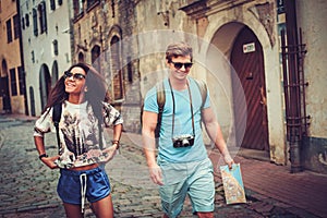 Multi ethnic tourists couple with map in old city
