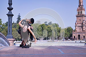 Multi-ethnic young couple doing figures while dancing bachata sensually outdoors