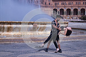 Multi-ethnic young couple doing figures while dancing bachata sensually outdoors