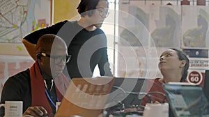 Multi-ethnic young students are talking at table with laptops while studying at university irrl.