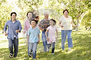 Multi-generation Asian family running in park