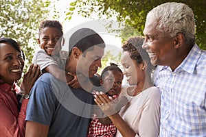 Multi generation black family look at each other in garden