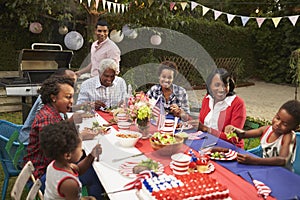 Multi generation black family at table for 4th July barbecue