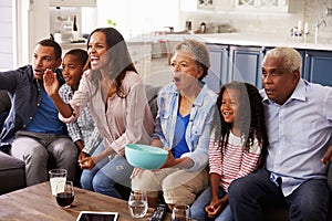 Multi generation black family watching sport on TV at home