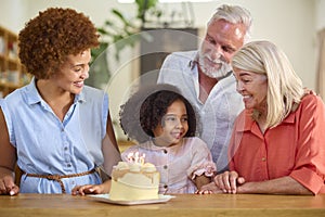 Multi-Generation Family Celebrating Granddaughter\'s Birthday At Home With Cake