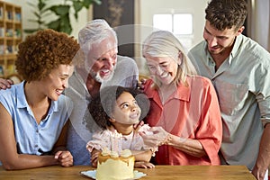Multi-Generation Family Celebrating Granddaughter\'s Birthday At Home With Cake