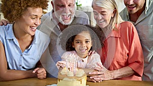 Multi-Generation Family Celebrating Granddaughter\'s Birthday At Home With Cake