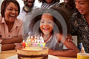 Multi-Generation Family Celebrating Granddaughters Birthday At Home With Cake And Candles