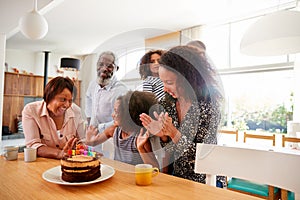 Multi-Generation Family Celebrating Granddaughters Birthday At Home With Cake And Candles