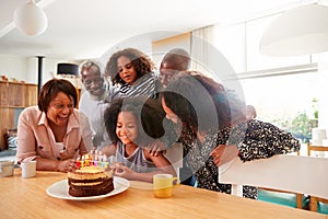 Multi-Generation Family Celebrating Granddaughters Birthday At Home With Cake And Candles