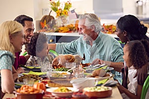 Multi-Generation Family Celebrating Thanksgiving At Home Eating Meal Together