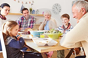 Multi Generation Family Eating Lunch At Kitchen Table