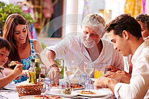 Multi Generation Family Eating Meal At Outdoor Restaurant photo