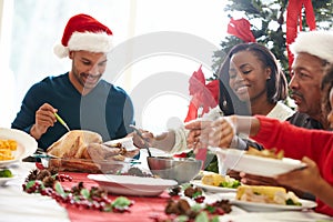 Multi Generation Family Enjoying Christmas Meal At Home