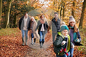 Multi-Generation Family Enjoying Walk Along Autumn Woodland Path Together