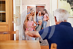 Multi Generation Family With Grandchildren Visiting Grandparents At Home