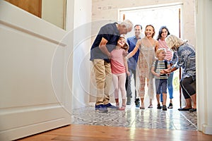 Multi Generation Family With Grandchildren Visiting Grandparents At Home