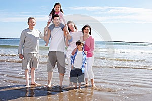 Multi Generation Family Having Fun On Beach Holiday