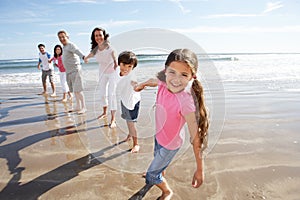 Multi Generation Family Having Fun On Beach Holiday