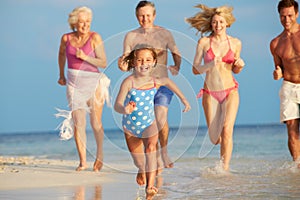 Multi Generation Family Having Fun In Sea On Beach Holiday